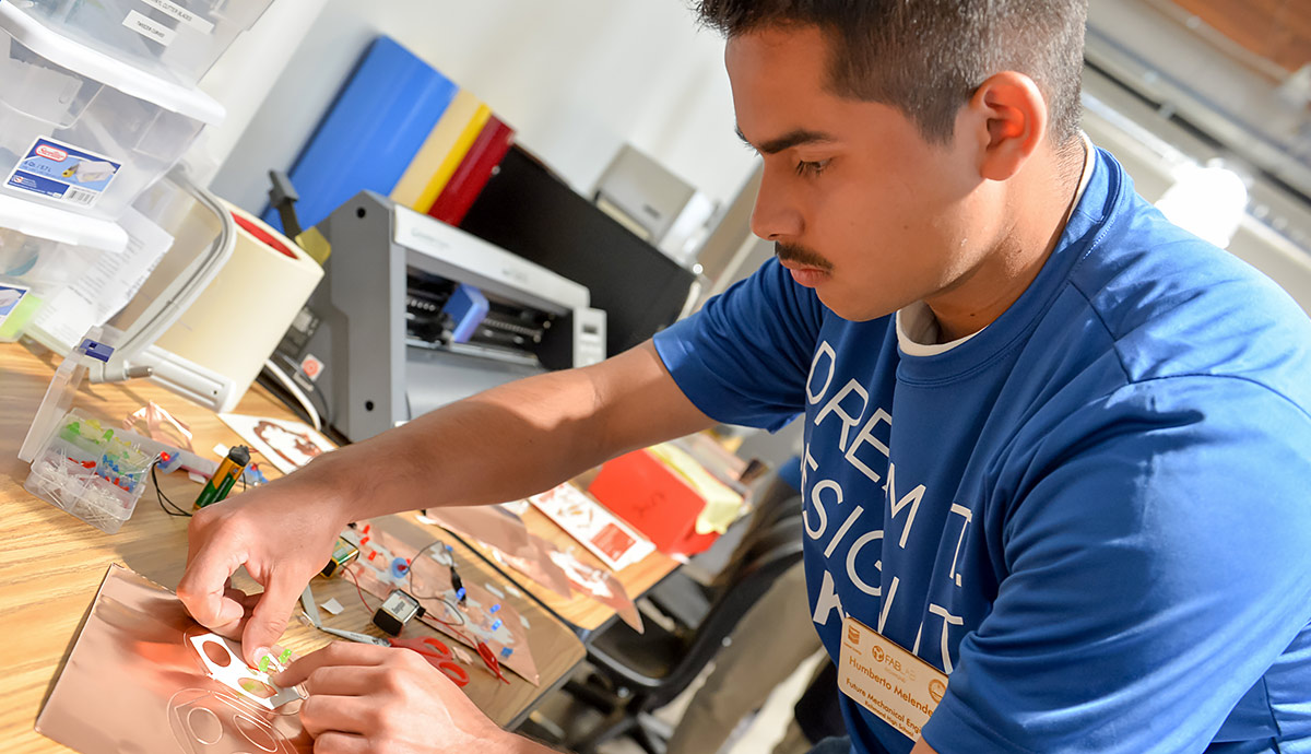 A boy works on an engineering activity at the STEM Zone.